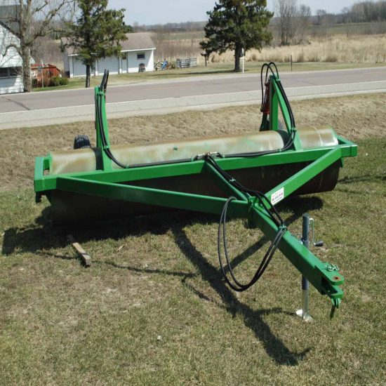 Durable green lawn roller with hydraulic controls for soil compaction and landscaping projects.